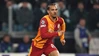 Ein Fußballprofi im rot-gelb geteilten Galatasaray-Trikot in dynamischer Laufbewegung auf dem Spielfeld während eines Champions-League-Spiels.